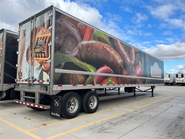 A trailer that is part of a fleet showing branded fleet vehicle graphics